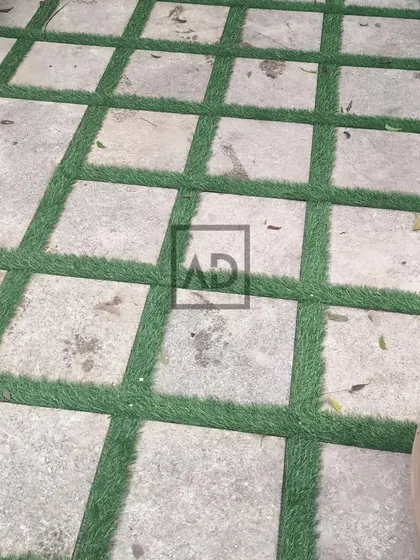 A creative flooring solution where I've laid artificial grass in the gaps between large stone pavers. This creates a unique, geometric look for a patio or walkway.