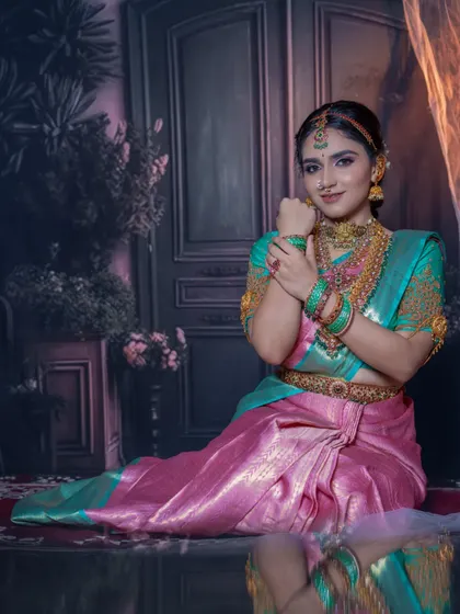 The reflection in this shot adds a beautiful artistic touch. It shows the full look, including the elegant drape of the saree and the detailed hair styling.