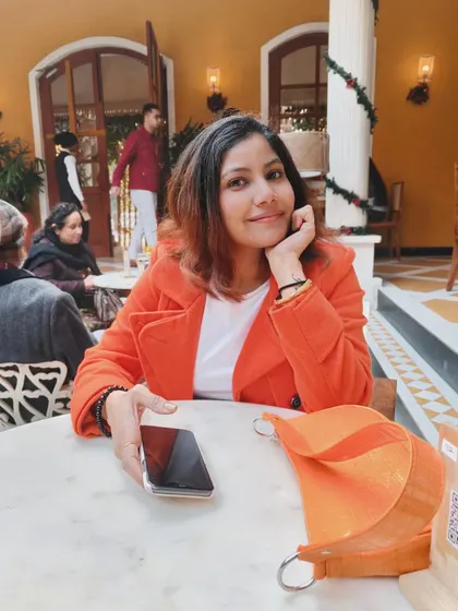 A candid moment from a lunch outing. A bright orange coat over a simple white t-shirt is an easy way to look put-together and add a cheerful pop of color to your day.