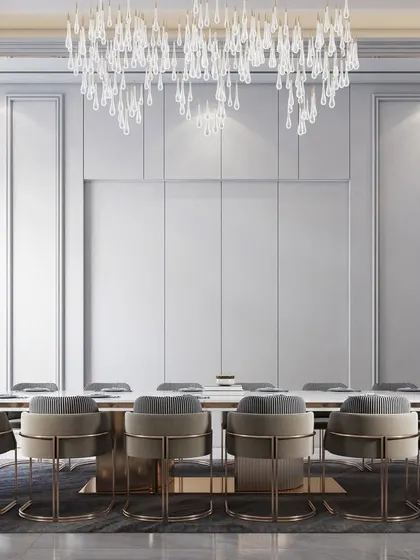 A formal dining room with a minimalist aesthetic, featuring a large table under a crystal chandelier and clean, white panelled walls.