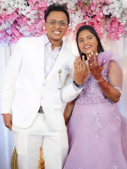 The couple proudly showing off their engagement rings. The bride is wearing a modern lavender gown with soft, romantic makeup.