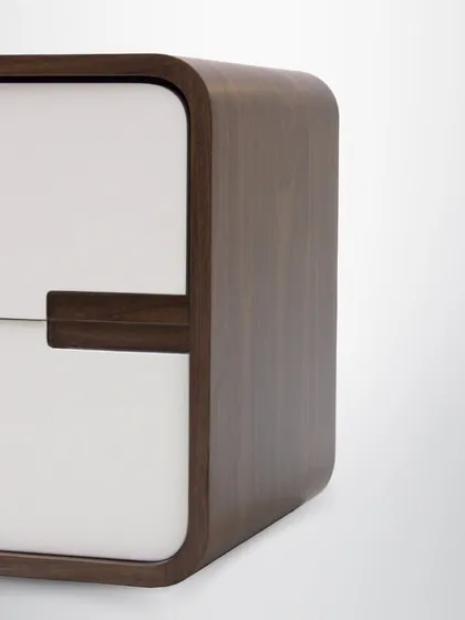 A detail of the side table, highlighting the seamless joinery and the beautiful contrast between the dark wood frame and the light-colored drawer front.