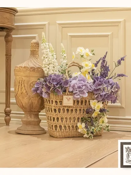 This beautiful basket of purple and white artificial flowers brings a touch of rustic, countryside charm to the floor of this elegantly decorated room. It's a lovely way to add color and texture.