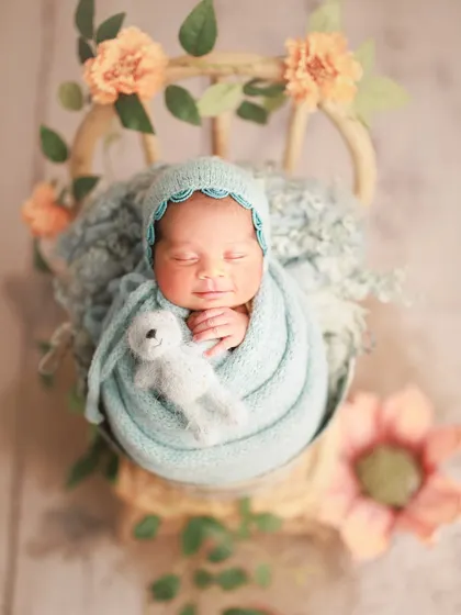Cradled in hues of sea blue and peach petals. This combination of colors and props creates a delicate and artistic masterpiece.