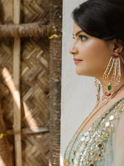 A profile shot focusing on the bride's beautiful jewelry and the natural textures of the backdrop. A simple, elegant portrait.