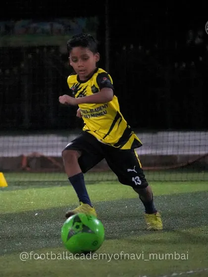 A young player practices dribbling with a green ball, showing focus and control. I use different types of equipment to keep training engaging and effective.