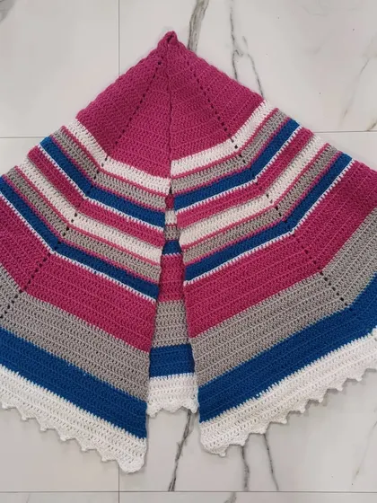 This is the fuschia and grey semi-circle shawl laid flat to show its full shape and striped pattern. It's a versatile wrap that can be styled in many different ways.