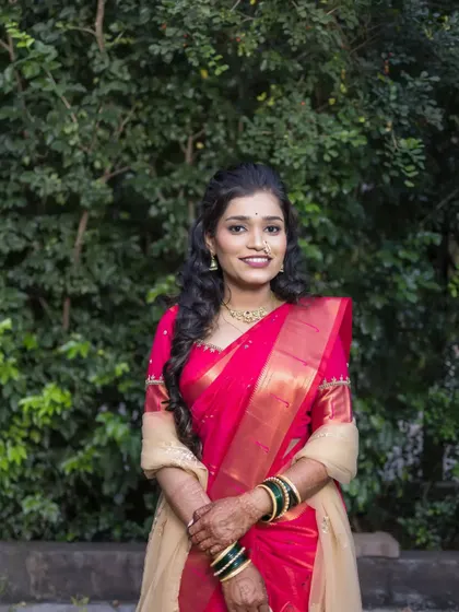A classic and elegant portrait of the bride, her hands clasped, looking directly at the camera with a warm smile.