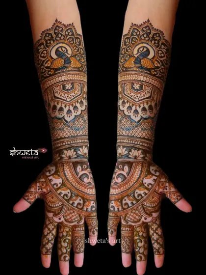 An elbow-length design perfect for a bride or her close family. This pattern features a beautiful blend of peacock and elephant motifs with intricate detailing.