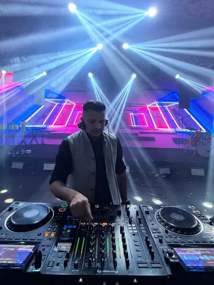 A focused moment at the DJ console during a destination wedding in Singapore. The lighting rig here was massive, creating beams that filled the entire hall.