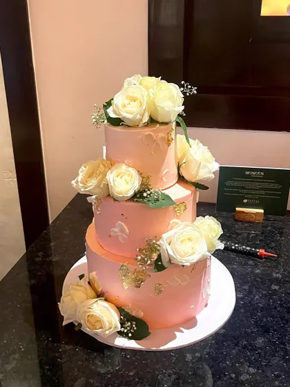 For grand celebrations, I love creating tiered cakes like this one. This three-tiered beauty features a vanilla sponge, is filled with fresh strawberry and blueberry filling, and is decorated with fresh white roses and delicate gold leaf accents.
