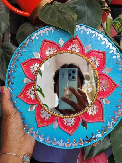 A selfie reflection in the lotus Lippan art mirror, showing its size and reflective quality.