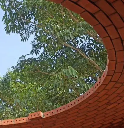The open oculus of the brick dome frames the sky, creating a natural connection to the outdoors.