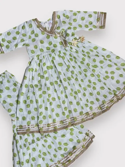 This soft cotton Angarkha and sharara set features a delicate green leaf print with subtle gold detailing. It’s an elegant and comfortable choice for festive gatherings.