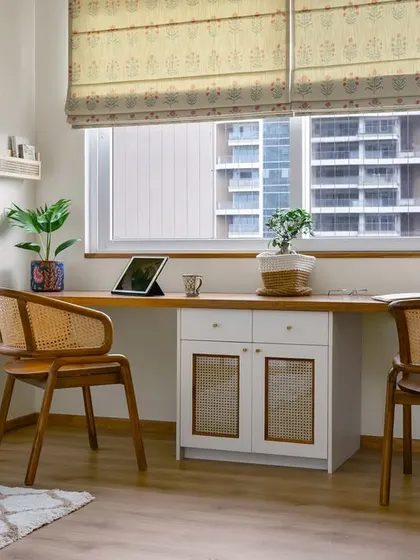 This two-person workspace in the 'Malhar' home office is perfect for a couple working from home. The long desk provides ample room, while the central cabinet with cane shutters adds storage and texture.