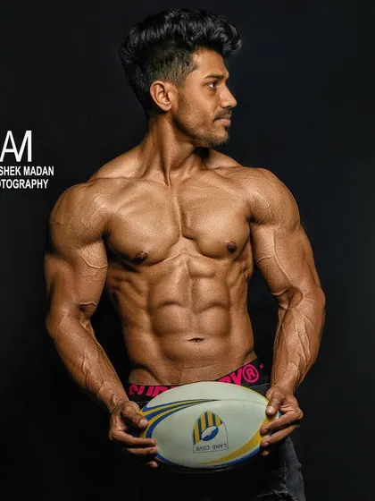 A professional shot of a client after his 16-week transformation. He looks like an athlete, ready for a photoshoot or the stage.