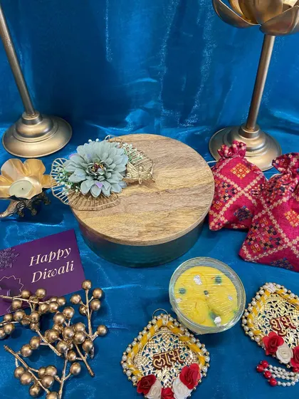 The closed view of our round gift box with a wooden lid, adorned with a flower. This elegant packaging is perfect for a surprise Diwali gift.