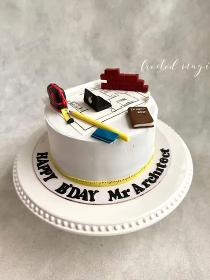 A cake for an architect, complete with edible blueprints, a measuring tape, and other tools of the trade. It's a simple yet thoughtful design that celebrates a person's profession.