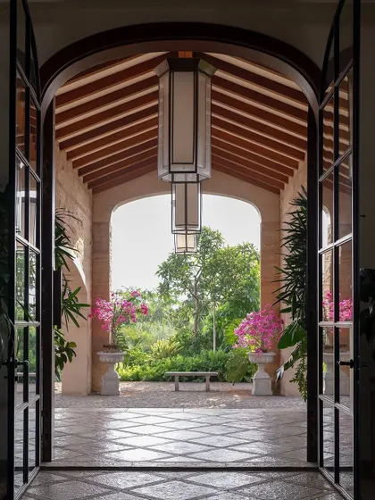 A grand entrance should feel like a welcoming embrace from nature. For this Alibaug villa, I framed the garden view with an archway, creating a living picture that draws you in. The flowering bougainvillea adds a splash of color, promising a serene escape within.
