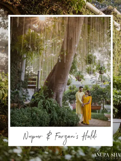 A wide, scenic shot of the couple under a beautifully decorated tree during their Haldi. This image captures the scale and beauty of their outdoor wedding decor.