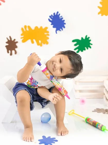 A moment of pure, uninhibited fun. This candid shot perfectly captures the playful spirit of the Holi festival.