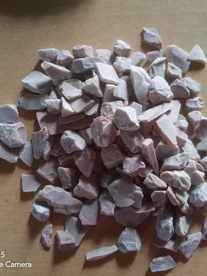 A pile of light pinkish, unpolished stone chips.