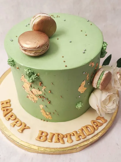 We combine modern elegance and classic flavors in this sage green cake. Adorned with gold leaf, delicate white roses, and gold-dusted macarons, this design is a sophisticated and stylish choice for a special birthday celebration.