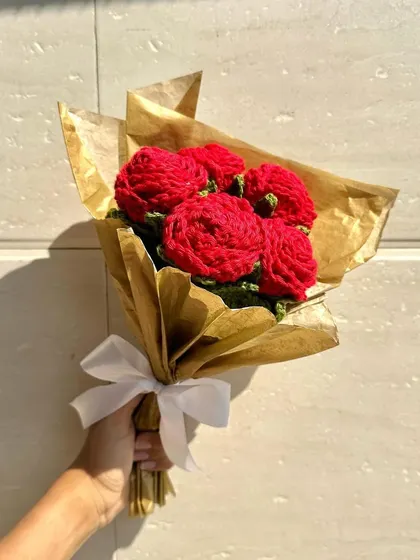 A classic bouquet of six vibrant red crochet roses, wrapped in shimmering gold paper. This is a timeless gift that says "I love you" and lasts a lifetime.