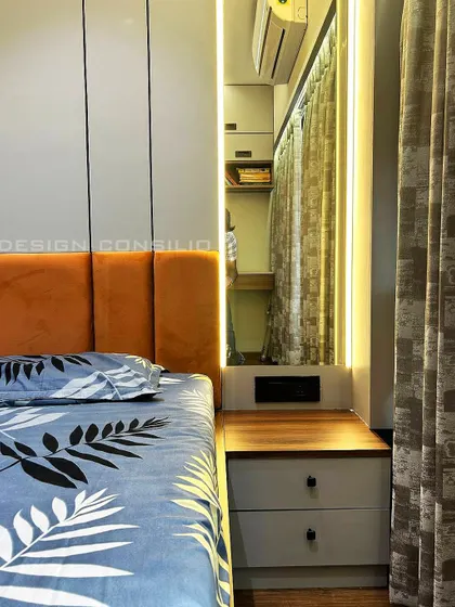 A close-up of a bedroom design showing a compact bedside table and a full-length mirror with backlighting. These small details add to the functionality and ambiance of the room.