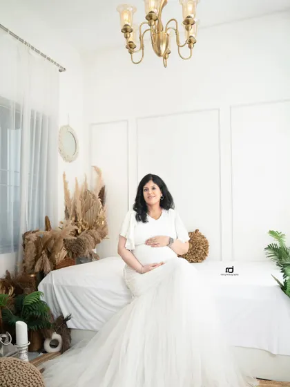 A beautiful solo portrait in a white mermaid gown. This shot, taken in my bright and airy boho-themed studio set, perfectly captures the pregnancy glow.