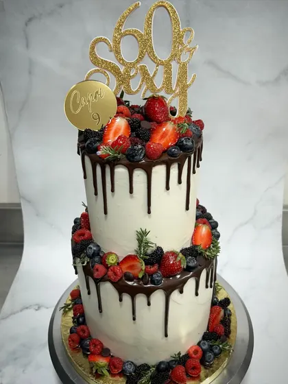 Go big or go home! This two-tiered "60 & Sexy" drip cake is loaded with fresh berries, including strawberries, blueberries, and raspberries. Inside, it's my signature 3 Berry Victoria with vanilla sponge and Swiss meringue buttercream. It’s a perfect example of how I use fresh, honest ingredients to create a showstopper.