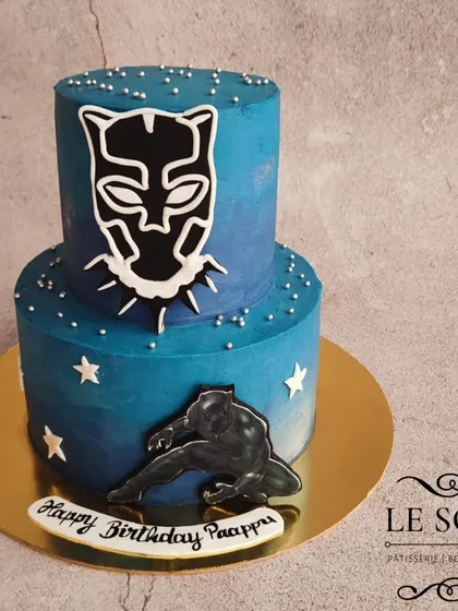 A powerful Black Panther two-tier cake for a superhero fan. This 1.5 kg Vanilla Caramel cake has a cool blue ombre finish and is decorated with the Black Panther mask and silhouette.