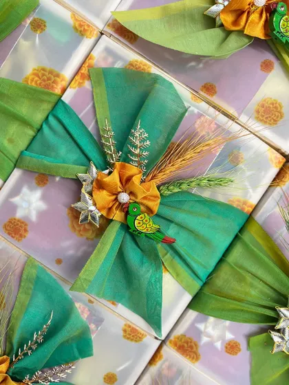 A festive gift wrapped with a beautiful green and yellow bow, adorned with a miniature parrot embellishment, capturing the joyful spirit of Indian festivals.