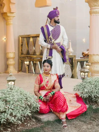 A regal portrait of the couple in their stunning purple and white Maharashtrian wedding outfits.
