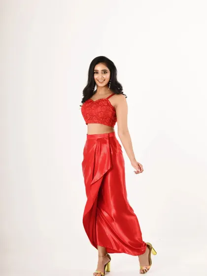 A full-length shot of a designer red two-piece outfit. The bright, even lighting is perfect for showcasing a designer's creation for a lookbook.
