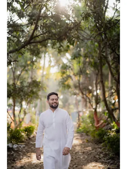 A happy portrait of the groom walking along a path, enjoying the moments before his Haldi ceremony.