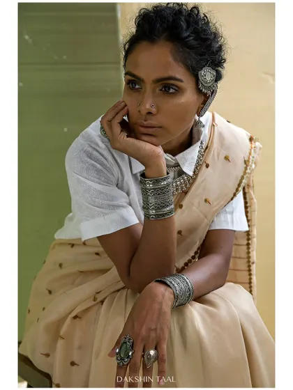 A close-up on the thoughtful expression and the beautiful stacked silver jewelry. These detail shots are essential for telling the full story of the styling.