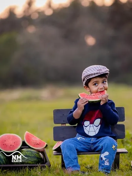 A summer evening enjoying watermelon in the park. The golden light of sunset adds a warm and beautiful glow to this outdoor session.