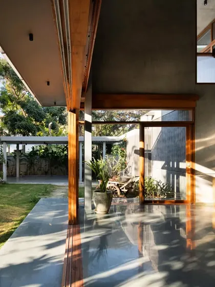 The play of morning light and shadow across the polished concrete veranda. The home's structure is designed to interact with the sun's path, creating a dynamic visual experience throughout the day.