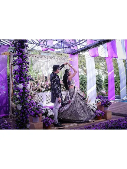 A beautiful shot of the couple dancing under their stunning purple-themed mandap.