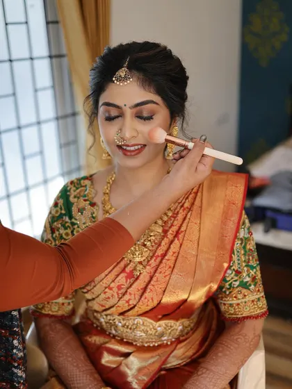 A behind-the-scenes moment, adding a touch of blush to bring a lovely flush to her cheeks. This is key to achieving that fresh, bridal glow.