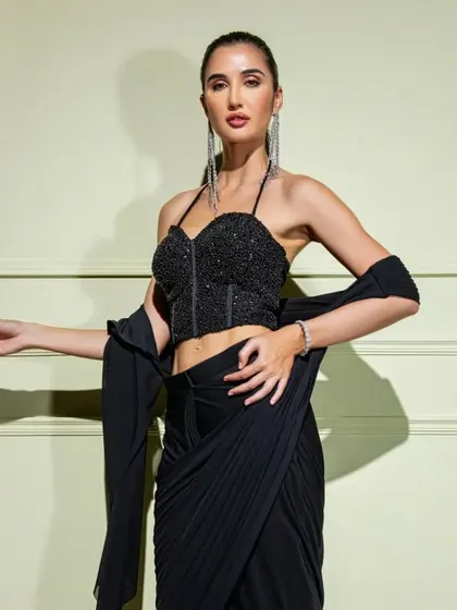 A closer look at the black drape saree with a structured halter-neck corset, perfect for a bold and modern statement.