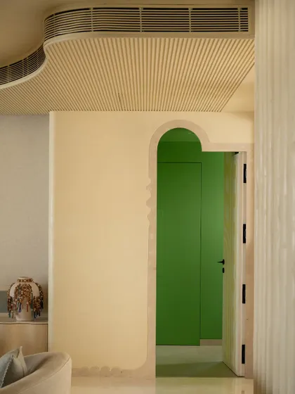 A playful pop of green is revealed through an arched doorway, a recurring motif in the Soft Serve apartment.
