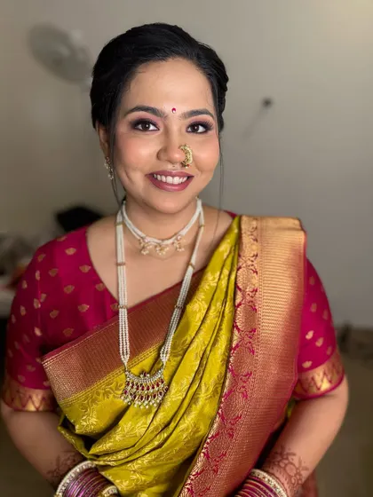 A beautiful traditional look for any occasion. The lime green saree with a pink blouse is a classic combination, enhanced by pearl jewelry and soft makeup.