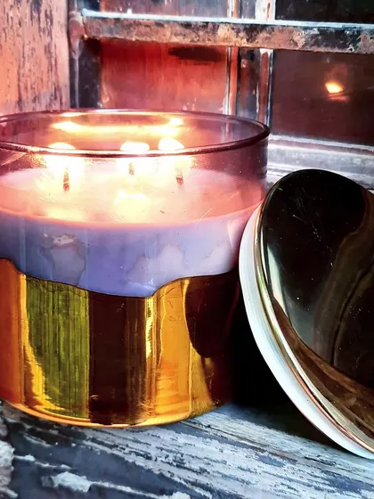 A luxury 3-wick scented candle in a smoked glass jar with a gold bottom and a matching gold lid. This is a perfect statement piece for your decor.