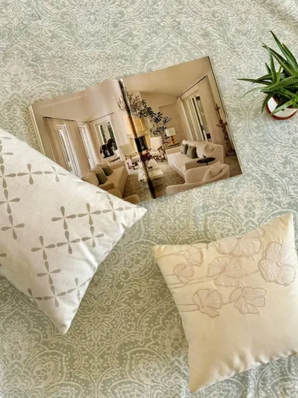 A flat lay of our hand-detailed cushions on a jacquard rug, showcasing the subtle patterns and textures. This is how we create soft luxury, through thoughtful design and a commitment to peaceful, beautiful living.