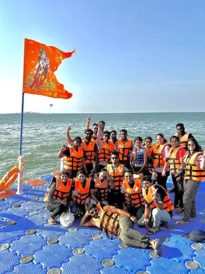 Our group on a floating platform in the sea, with a flag flying high, celebrating a long weekend trip.