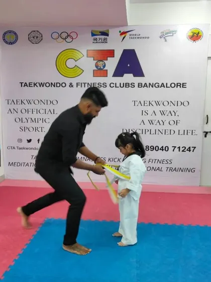 Tying a yellow belt for a young girl.