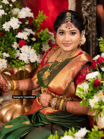 Seated amidst flowers, this bride radiates pure elegance. The makeup is designed to be both beautiful and long-lasting, perfect for the main wedding ceremony.