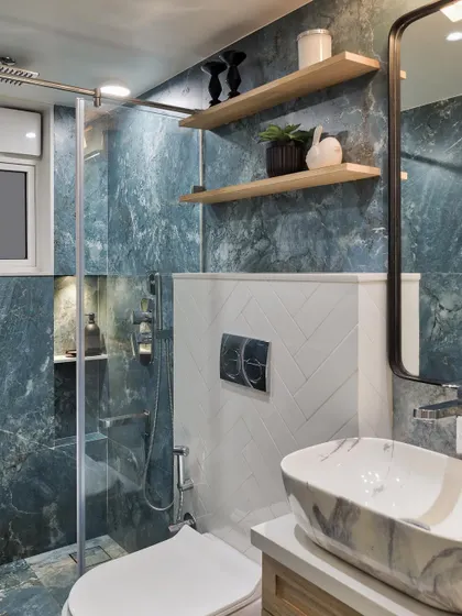The powder bathroom of Apartment 1101 is simple yet elegant, featuring beautiful aqua marble finish tiles. On the ledge wall, classic white subway tiles and charming wooden shelves create a captivating contrast.